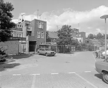 Gezicht op de achterzijde van de huizen Abstederdijk 33-hoger te Utrecht, vanaf een binnenstraat met parkeerplaatsen.
