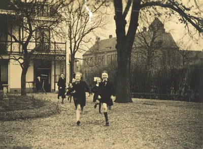 Afbeelding van enkele hollende kinderen in de tuin achter het huis van de familie Verlegh (Abstederdijk 327) te Utrecht. Rechts op de achtergrond de Koningin Wilhelminaschool aan de Mecklenburglaan.